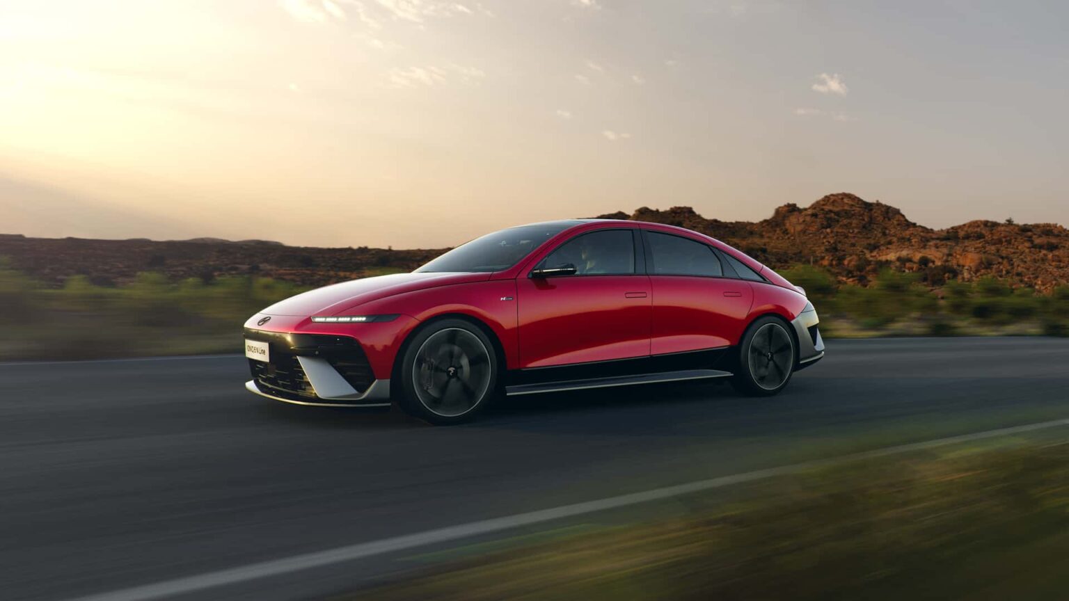 Mobilité électrique et durable : Hyundai Ioniq 6 N Line rouge roulant sur route au coucher du soleil