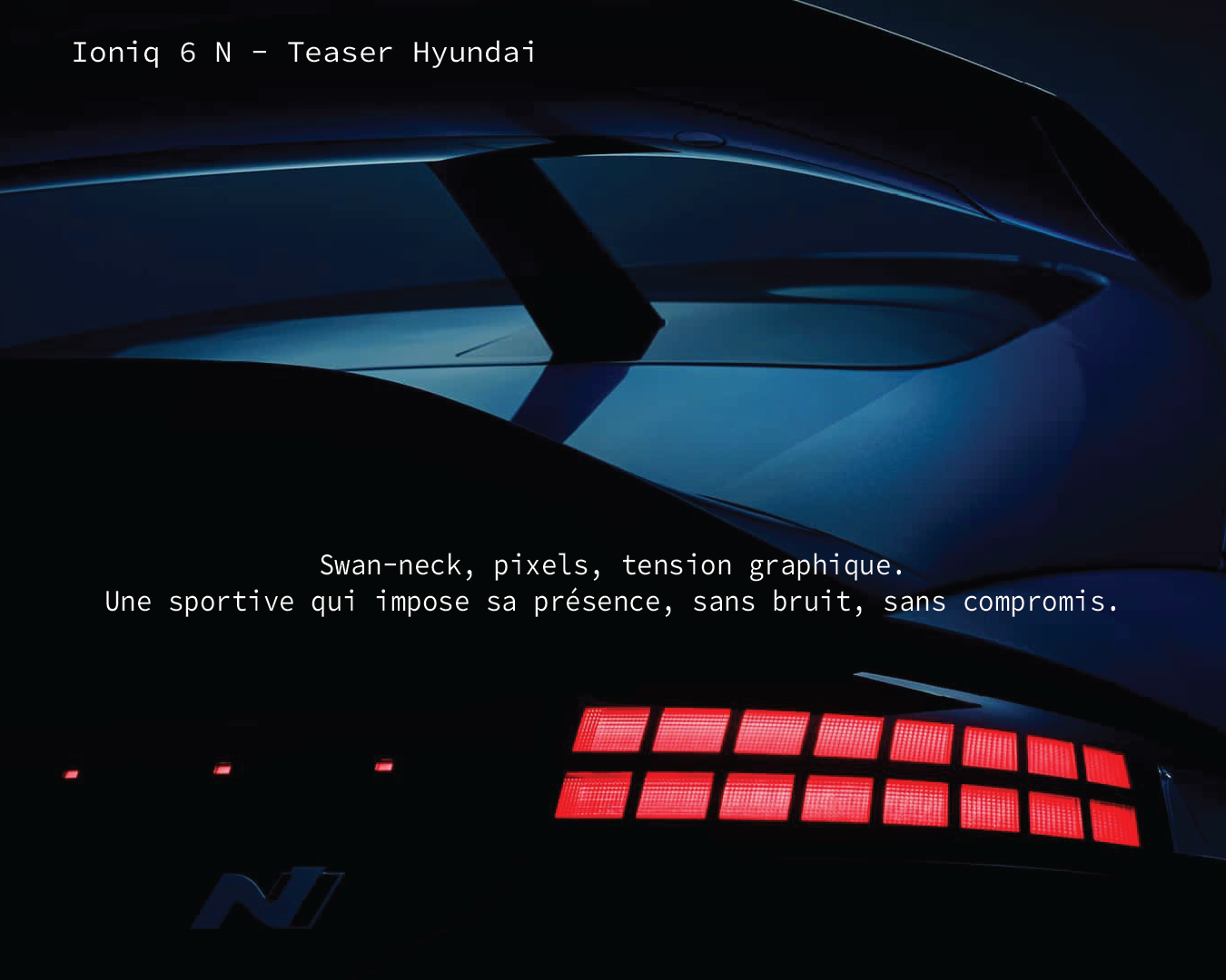 Teaser visuel diffusé par Hyundai en amont de la présentation de la IONIQ 6 N. L’image joue sur les ombres et les lumières pour suggérer la tension dynamique du modèle : projecteurs LED affûtés, lignes basses, présence quasi animale. À l’arrière-plan, une seconde IONIQ 6 laisse deviner l’aileron spécifique et la signature lumineuse arrière. Ce jeu de clair-obscur inscrit la N dans un registre radicalement sportif.