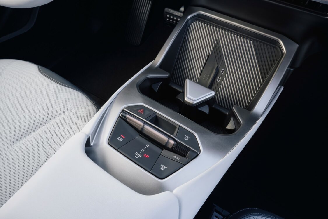 os plan sur la console centrale de la BMW iX3, avec les commandes de transmission, frein de parking, et rangements.