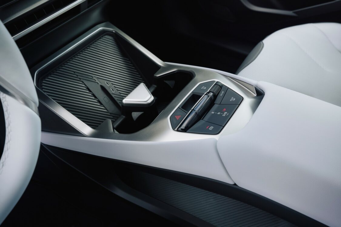 Vue latérale de la console centrale de la BMW iX3, avec commandes de transmission et rangement supérieur texturé.