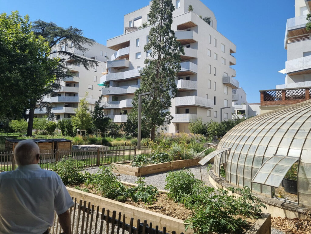 Vue du quartier Oasis Parc à Lyon : logements en accès libre, résidences sociales et jardins partagés, dans un cadre végétalisé.
