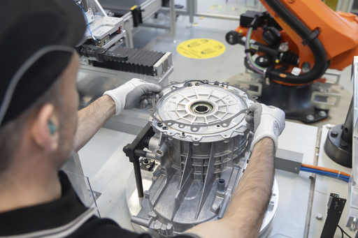 Opérateur Renault positionnant une pièce sur le moteur électrique 7DL à Cléon