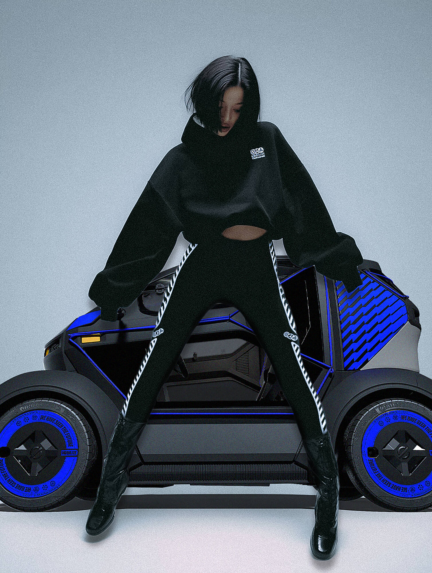Jeune femme vêtue de noir posant devant le showcar Mobilize Duo by TheArsenale, version customisée du quadricycle électrique de Renault.