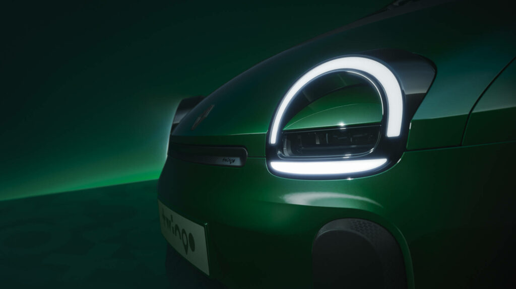 Gros plan sur le phare avant de la Twingo E-Tech electric, avec signature lumineuse en demi-cercle et logo Renault stylisé.