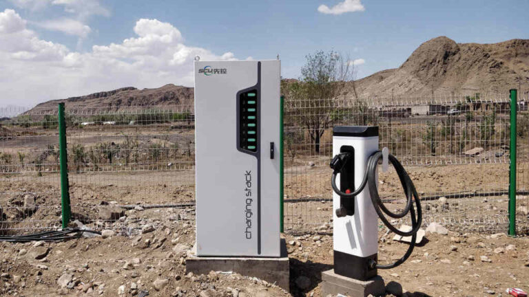 Borne de recharge rapide DC isolée dans un environnement minéral et contraint, sans usage immédiat visible.